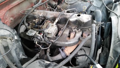 1981 Ford Bronco - The image shows a close-up view of a V8 engine bay, likely from a classic Ford Bronco, featuring a carburetor, exhaust manifold, and fan. T…