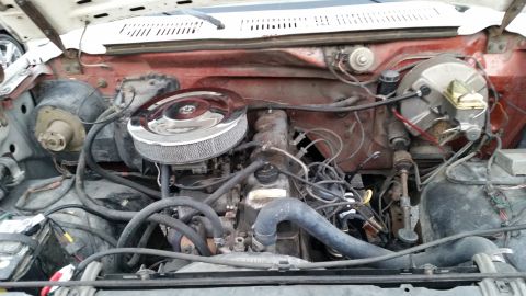 1981 Ford Bronco - The engine bay of a classic Ford Bronco is shown, featuring the engine, air cleaner, battery, brake booster, and various hoses and wires.