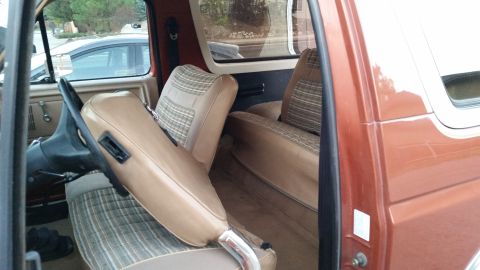 1981 Ford Bronco - Interior view of a vintage Ford Bronco showing the driver's seat and steering wheel, with the passenger seat visible behind it. The seats h…