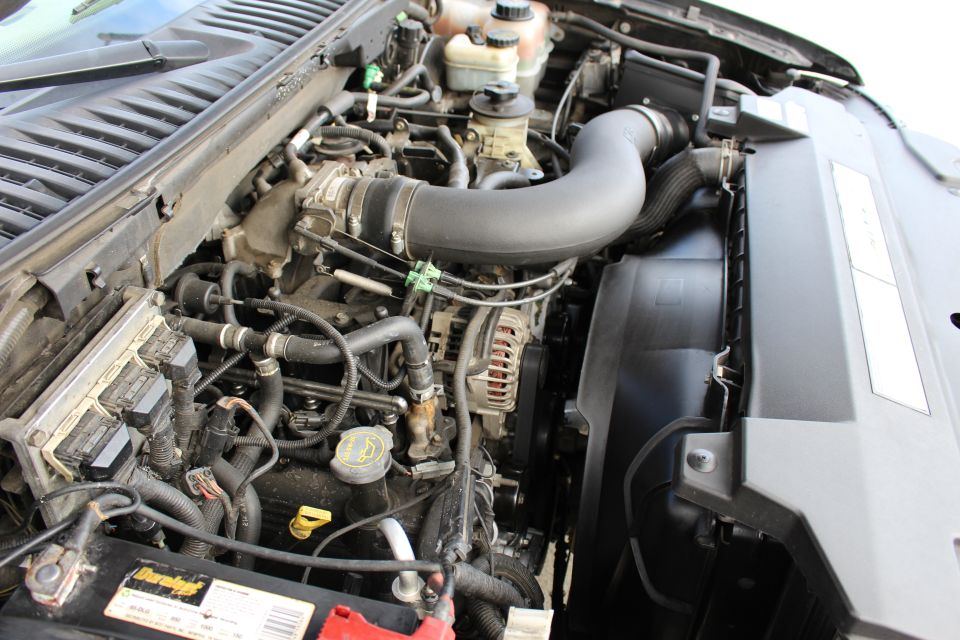 2003 Ford Expedition engine bay with V8 engine, air intake, radiator fan, and battery.