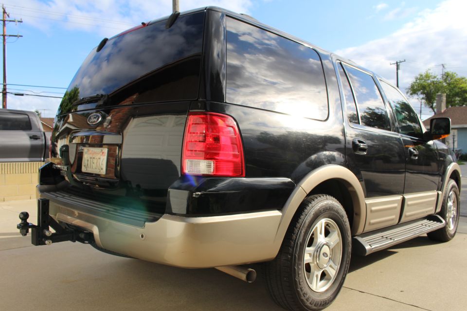 Black 2003 Ford Expedition SUV rear driver's side view with trailer hitch