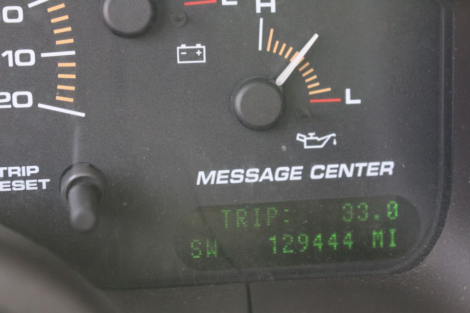 Close-up of a car dashboard showing trip odometer, mileage, and gauges.