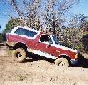 1990 Ford Bronco - This red 1990 Ford Bronco is shown off-roading and getting stuck in the mud.