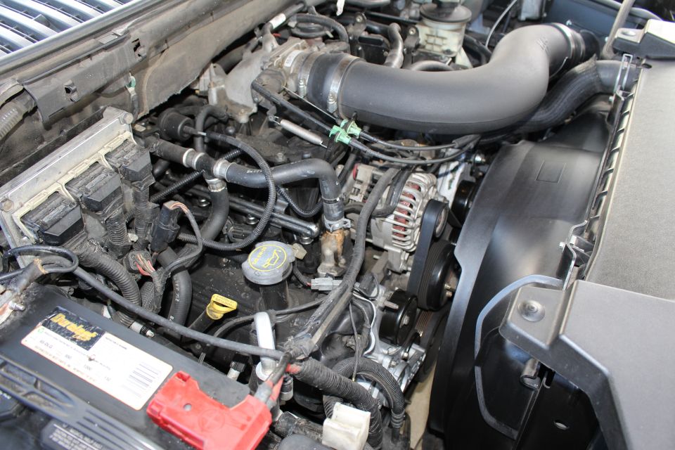 Engine bay with battery and fan shroud visible