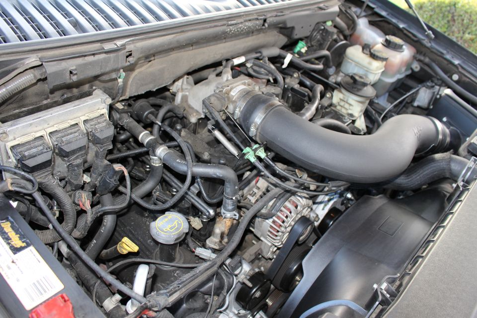 Engine bay with various hoses, wires, and engine components visible