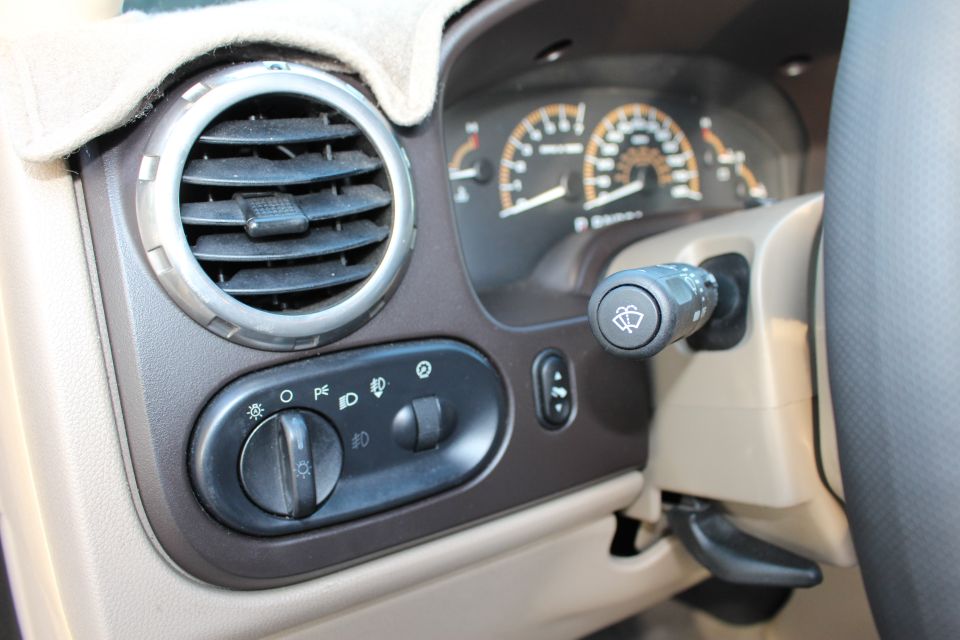2003 Ford Expedition interior dashboard with air vent, headlight controls, and wiper stalk