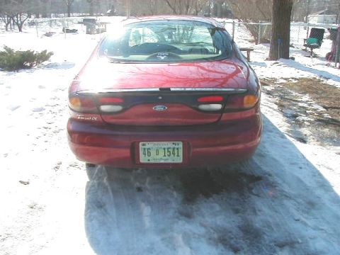 1997 Ford Taurus - Rear view of a red 1997 Ford Taurus parked in the snow.