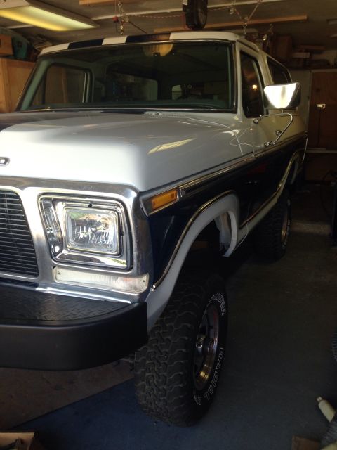 1978 Ford Bronco - This 1978 Ford Bronco is parked inside a garage, showing its distinctive two-tone paint and striped roof.