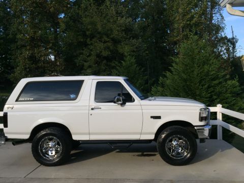 1995 Ford Bronco - Side view of a white 1995 Ford Bronco with aftermarket wheels and tires.