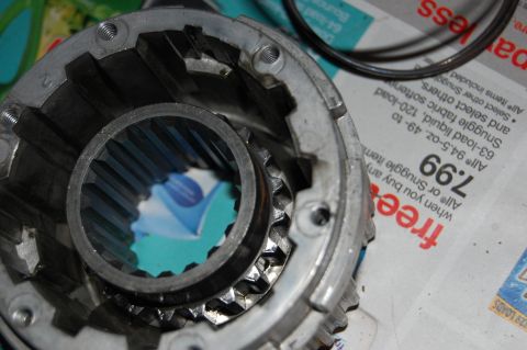 1994 Ford Bronco - Close-up of a metal gear part with visible internal splines, placed on a newspaper advertisement.