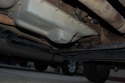 1994 Ford Bronco - The underside of a 1994 Ford Bronco is visible, its oil pan with the Ford emblem.