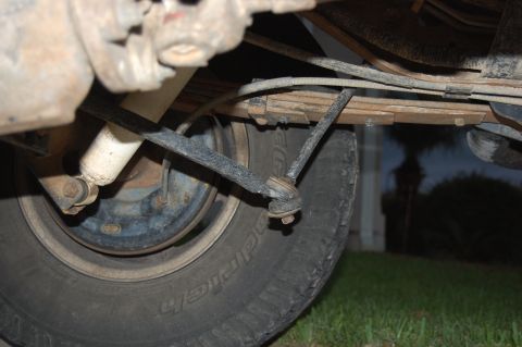1994 Ford Bronco - Close-up of the rear suspension components and tire of an older vehicle.