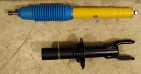 1993 Ford Thunderbird - Two automotive suspension parts are laid out on a workbench.
