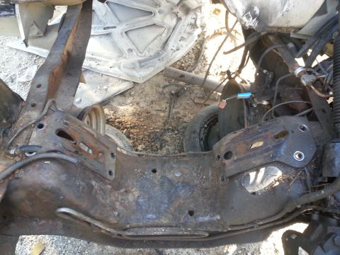 1994 Ford Bronco - Close-up of a heavily rusted vehicle frame and suspension parts, showing wear and tear.