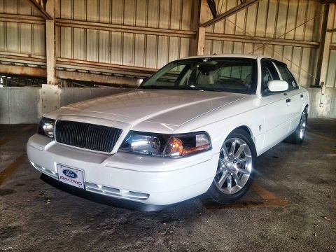 2000 Mercury Grand Marquis - A white 2000 Mercury Grand Marquis is parked indoors, a Ford Racing license plate frame and custom wheels.