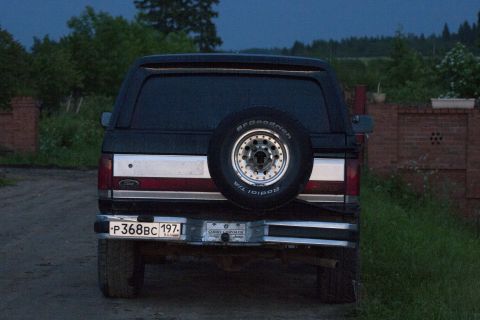 1987 Ford Bronco - Rear view of a 1987 Ford Bronco, showing the spare tire and license plate.