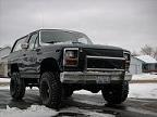 1986 Ford Bronco - This black SUV, likely from the early 1980s, is equipped with large off-road tires and a lifted suspension.