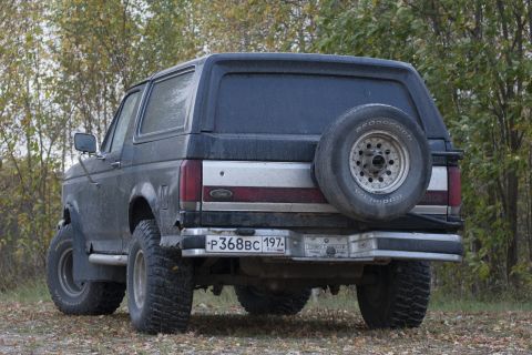 1987 Ford Bronco - This 1987 Ford Bronco is seen from the rear, its signature external spare tire and a dark gray finish.
