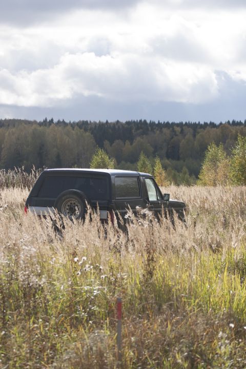 1987 Ford Bronco - 1987 Ford Bronco parked in a field of tall grass under a cloudy sky.