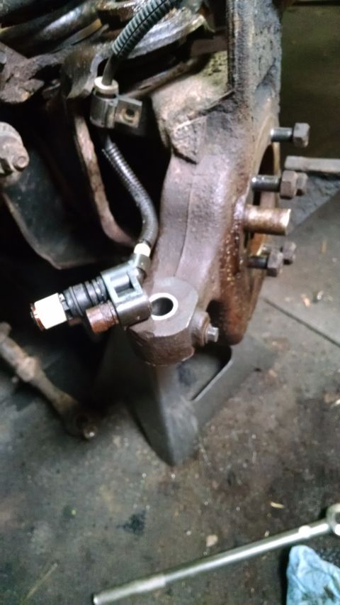 1994 Ford Bronco - Close-up of a wheel speed sensor mounted on a vehicle's suspension system, likely during a repair or rebuild.