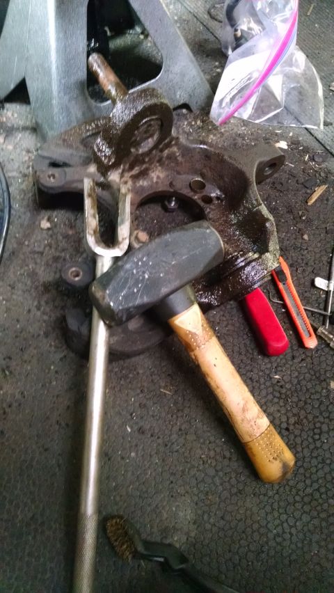 1994 Ford Bronco - Automotive spindle knuckle assembly and tools, likely for a front-end rebuild.
