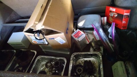 1994 Ford Bronco - Various car parts are organized in containers, suggesting a repair or parts inventory.