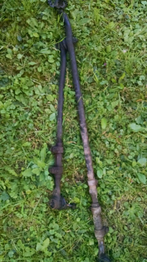 1994 Ford Bronco - Two tie rod ends are shown lying on a grassy surface.