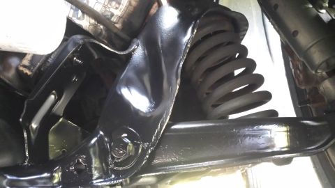 1980 Ford Mustang - Close-up of a vehicle's undercarriage, showing a suspension component and coil spring.