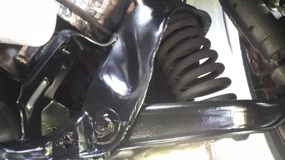 Black painted suspension arm and coil spring, viewed from below
