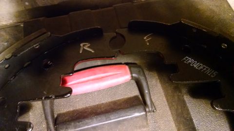1994 Ford Bronco - Two brake shoes are shown with markings indicating their placement, along with a tool.