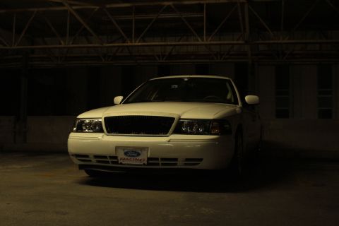 2000 Mercury Grand Marquis - A white Ford Crown Victoria is parked in a dimly lit garage.