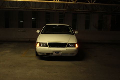 2000 Mercury Grand Marquis - A white 2000 Mercury Grand Marquis is shown from the front in a dimly lit indoor parking area.