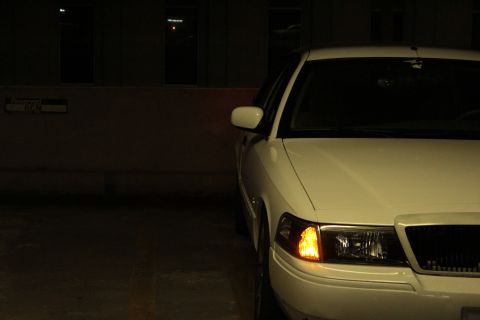 2000 Mercury Grand Marquis - A white 2000 Mercury Grand Marquis is parked, showing its front-right quarter and hazard light illuminated.