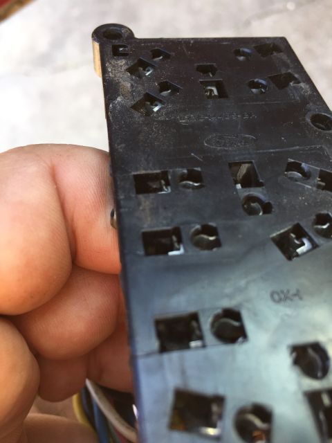 1989 Ford Bronco - Close-up of a vehicle's window and door lock control switch, showing internal connectors and a partial manufacturer logo.