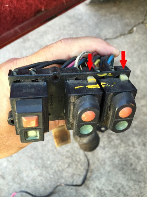 1989 Ford Bronco - Close-up of a vehicle's window and door lock switch assembly, held by a person's hand.