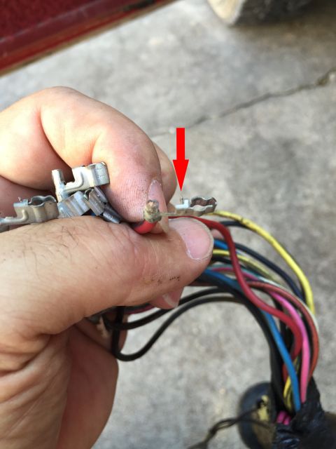 1989 Ford Bronco - Close-up of a wiring harness with a red arrow indicating a loose connector pin.