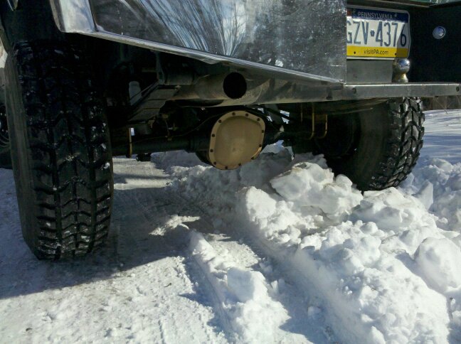Rear axle and tire of a vehicle stuck in snow, Pennsylvania license plate GZV-4376 visible