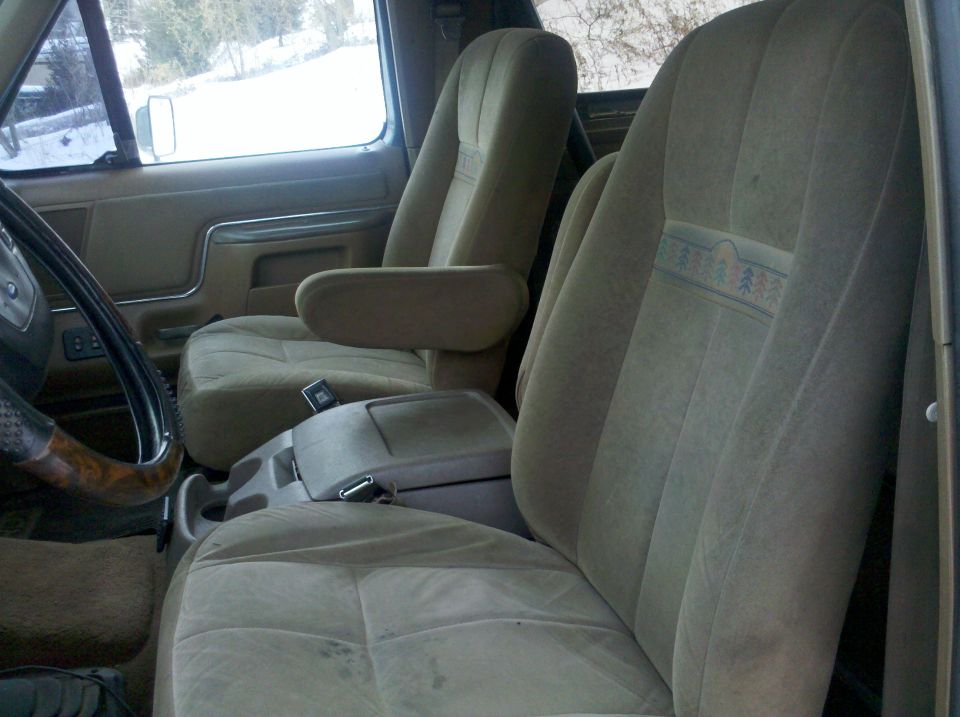 Front seats and center console of a truck. The seats are tan cloth with a patterned stripe