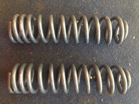1996 Ford Bronco - Close-up of two gray coil springs, possibly for a vehicle suspension system.