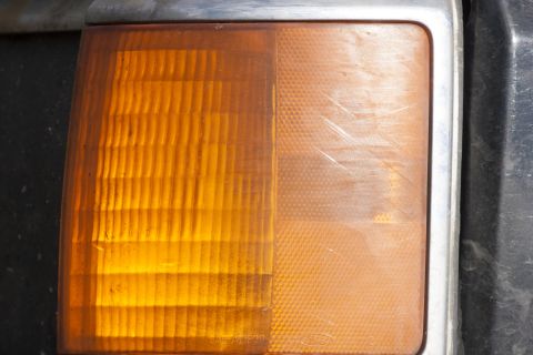 1987 Ford Bronco - This close-up shows the amber turn signal assembly of a vehicle, with distinct lens patterns and visible wear.