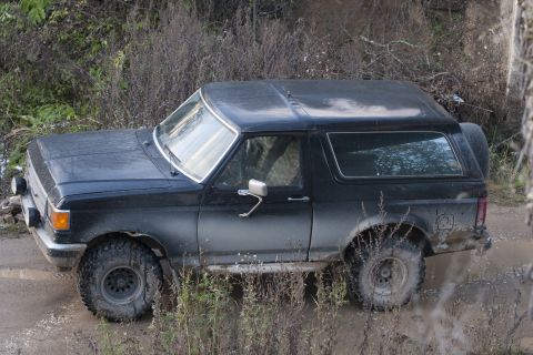 1987 Ford Bronco - This 1987 Ford Bronco is navigating a muddy off-road trail.