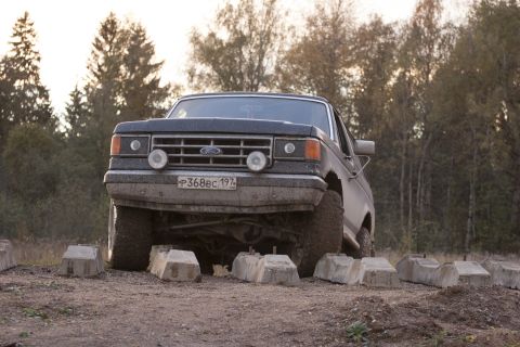 1987 Ford Bronco - A 1987 Ford Bronco is seen from the rear in a dusty outdoor setting.