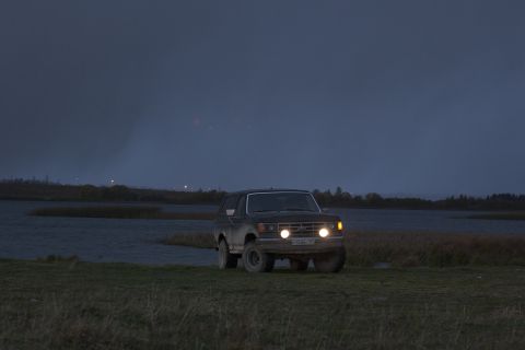 1987 Ford Bronco - 1987 Ford Bronco driving across a landscape as the sky darkens.