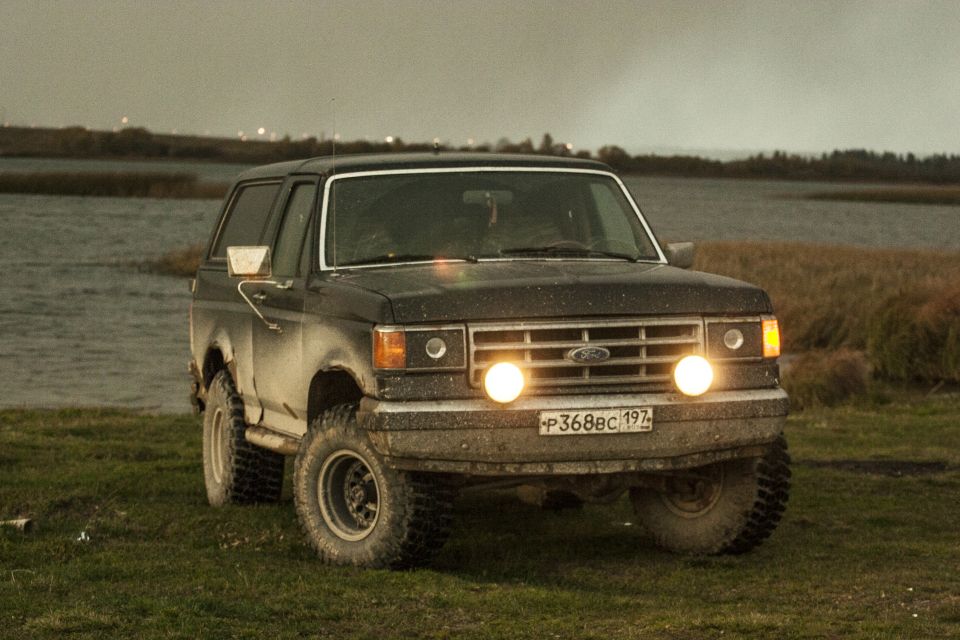 Front view of a 1987 Ford Bronco parked near water