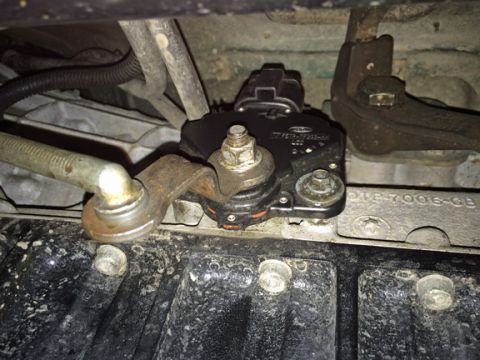 1990 Ford Bronco - Close-up view of a transmission shift interlock solenoid and associated linkage.