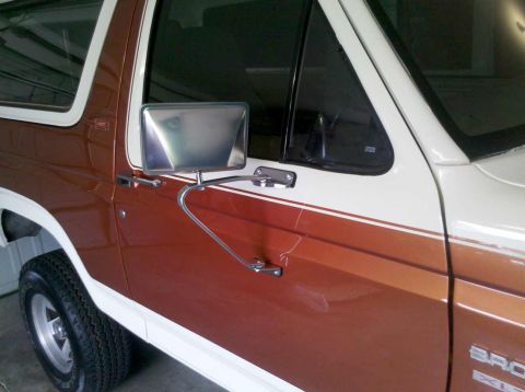 1982 Ford Bronco - Side view of a brown and white Ford Bronco, showing its door and side mirror.