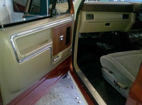 1982 Ford Bronco - Interior view of an older truck's door panel, dashboard, and seat.