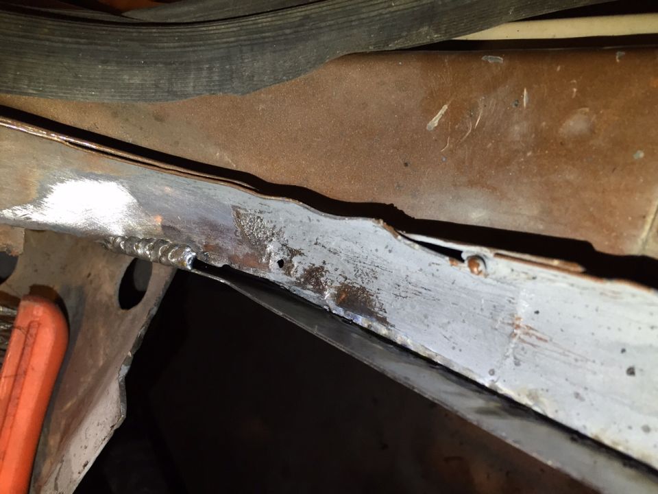 Close-up of rusted metal frame with visible welds and some grey primer