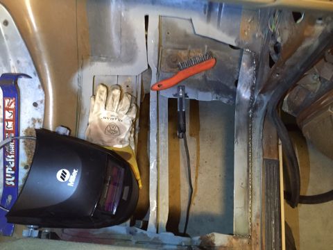 1991 Ford Bronco - Welding gear and protective gloves are laid out on the floor pans of a vehicle undergoing repair.