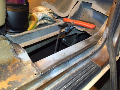 1991 Ford Bronco - This photo shows tools and a partially repaired rusty floor pan inside a vehicle.